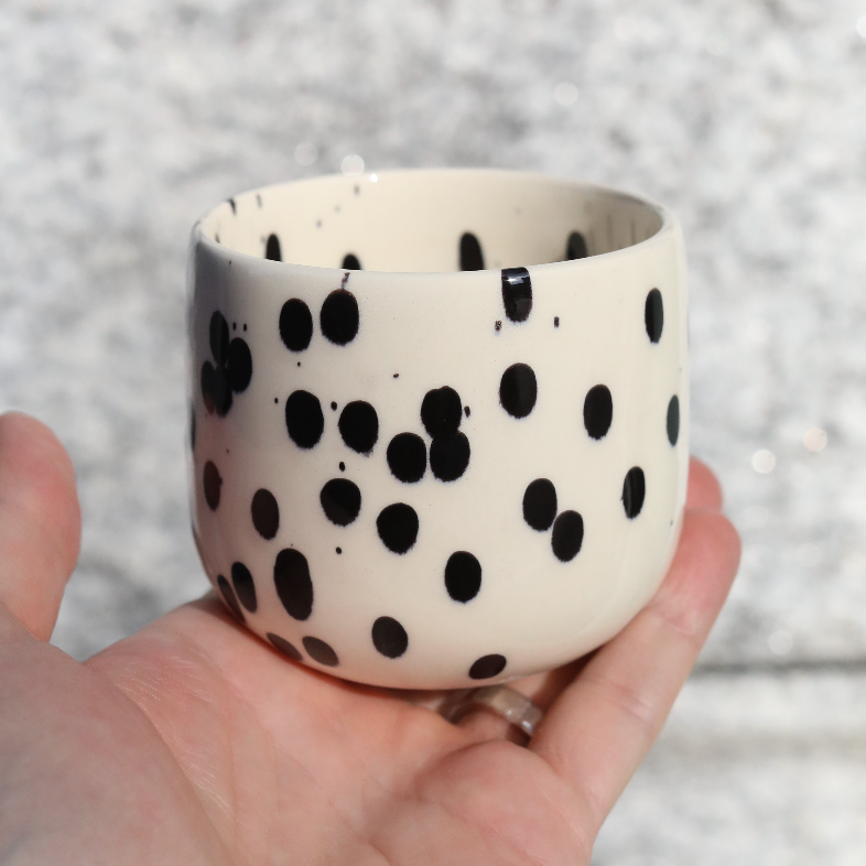 Tasse à café Black Dots pour latte macchiato en grès de 280 ml tenue à la main.