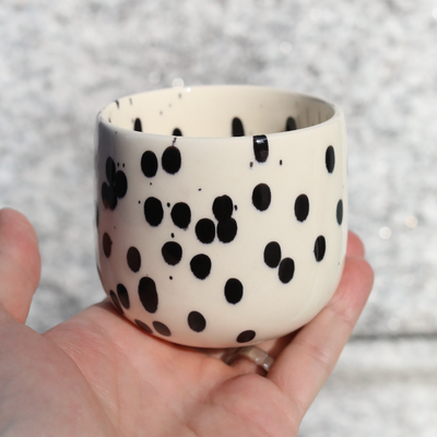 Tasse à café Black Dots pour latte macchiato en grès de 280 ml tenue à la main.