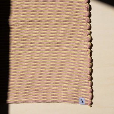 Close-up dans la lumière du soleil tapis de bain rayé en jaune et rose tissé à la main à partir de chutes de coton