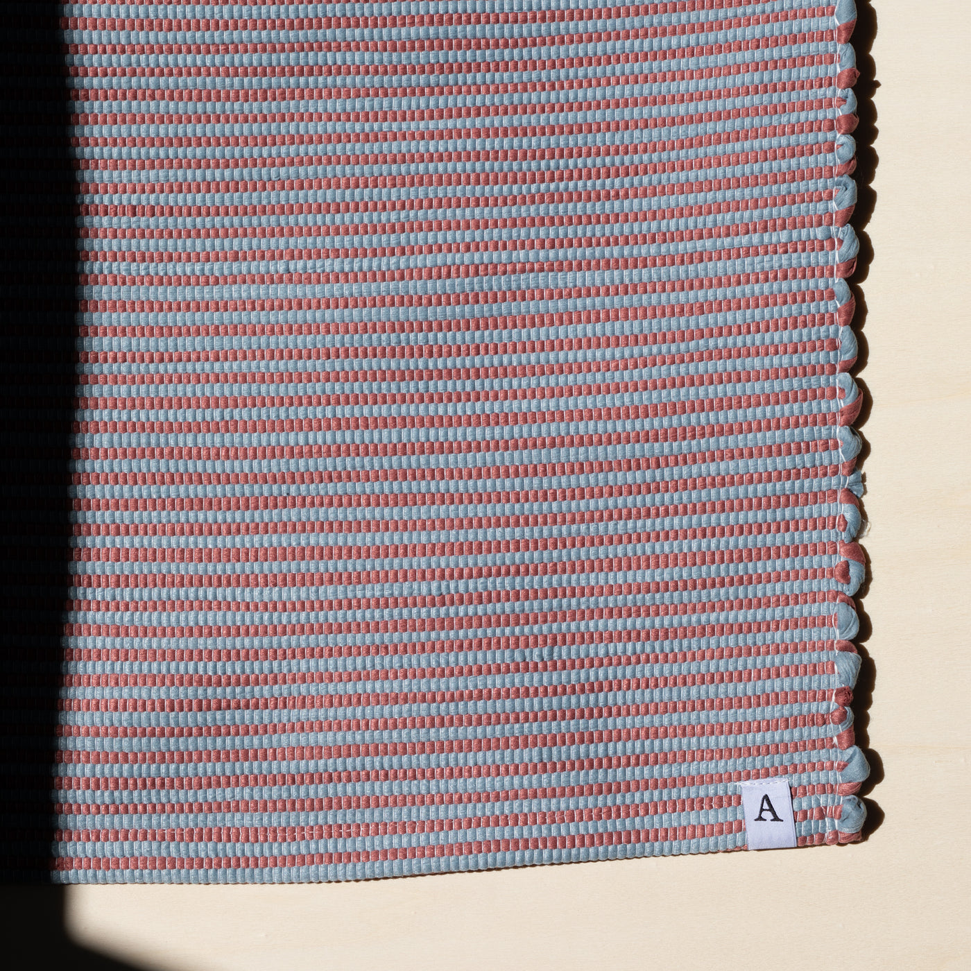 Close-up dans la lumière du soleil petit tapis 60x90cm rayé en rouge et bleu fait à la main au Portugal
