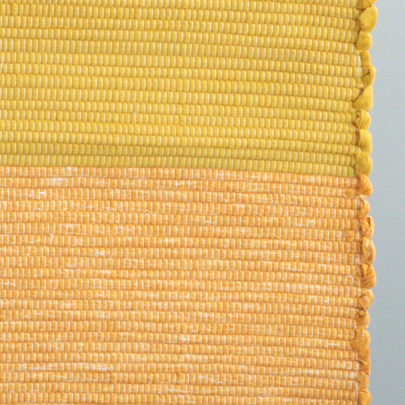 Close-up du tapis de 60x90cm en chutes de coton orange et jaune