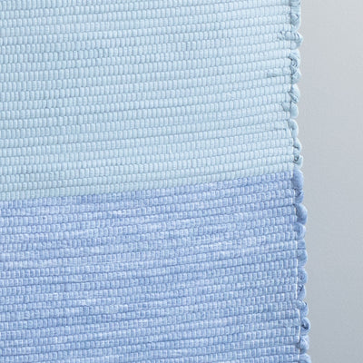 Close-up d'un tapis de bain bleu clair et bleu foncé tissé à la main