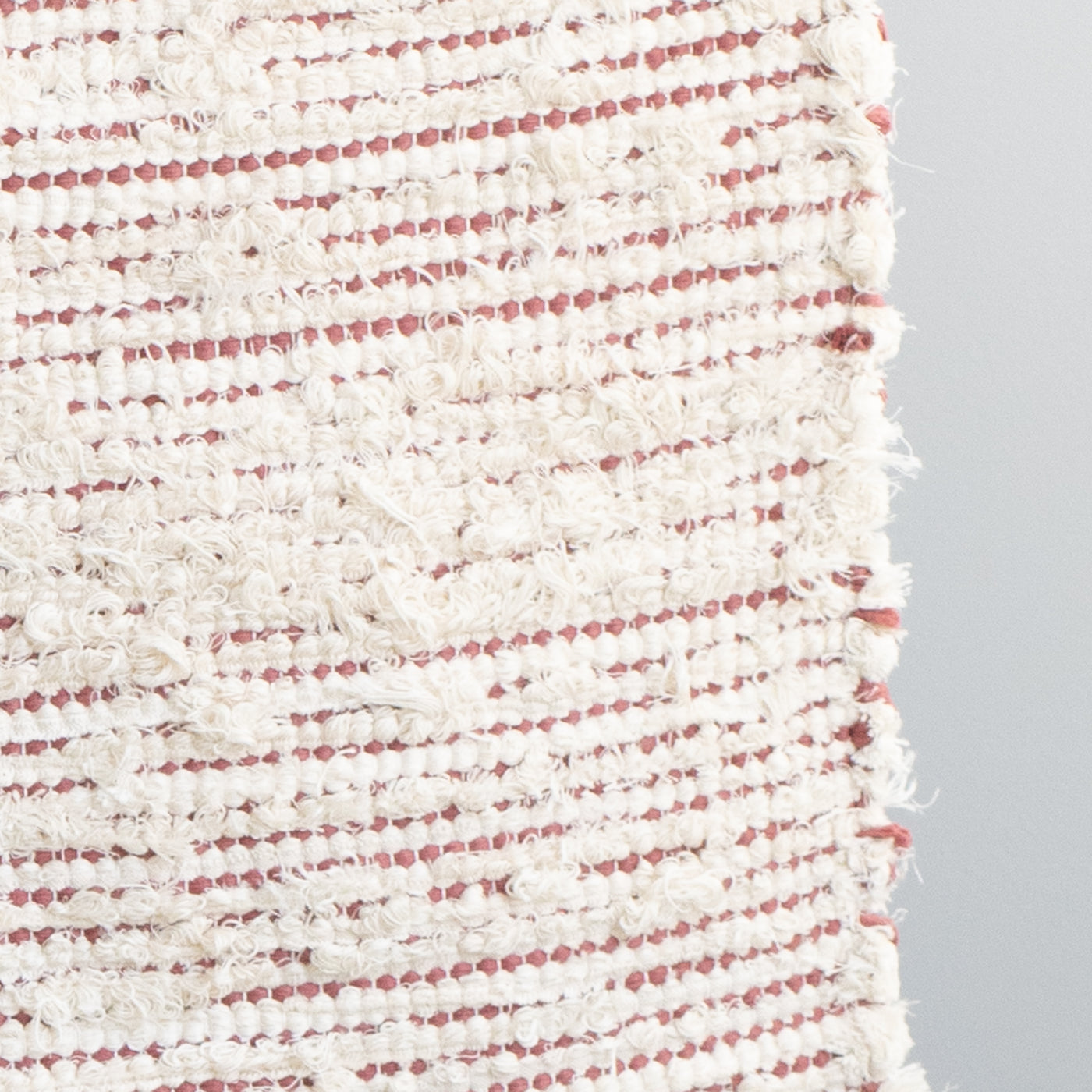 Closeup d'un tapis de salle de bain rayé avec du coton couleur pêche et du tissu éponge blanc tissé à la main au Portugal