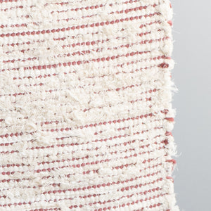 Closeup d'un tapis de salle de bain rayé avec du coton couleur pêche et du tissu éponge blanc tissé à la main au Portugal