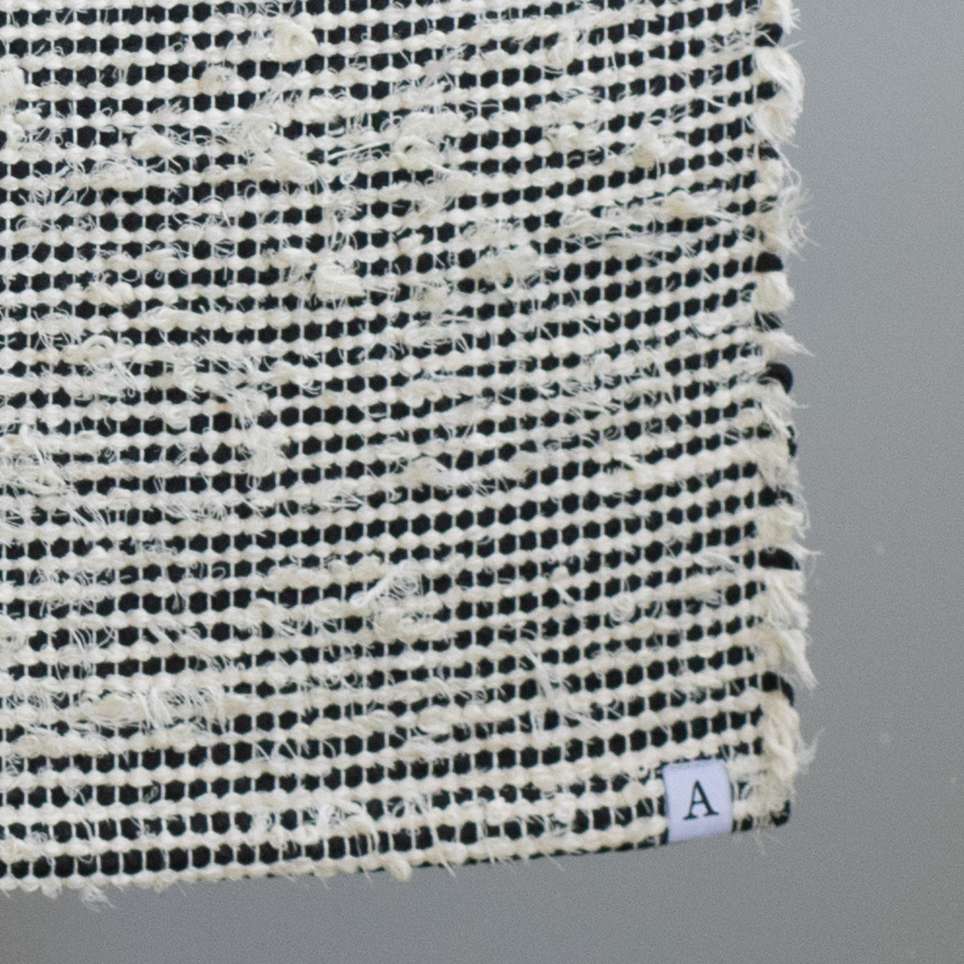 Closeup d'un tapis de salle de bain rayé avec du coton noir et du tissu éponge blanc 