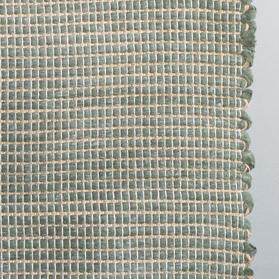 Close-up d'un tapis de bain vert rayé de jute fabriqué à partir de chutes de laine provenant de l'industrie textile et tissé à la main au Portugal