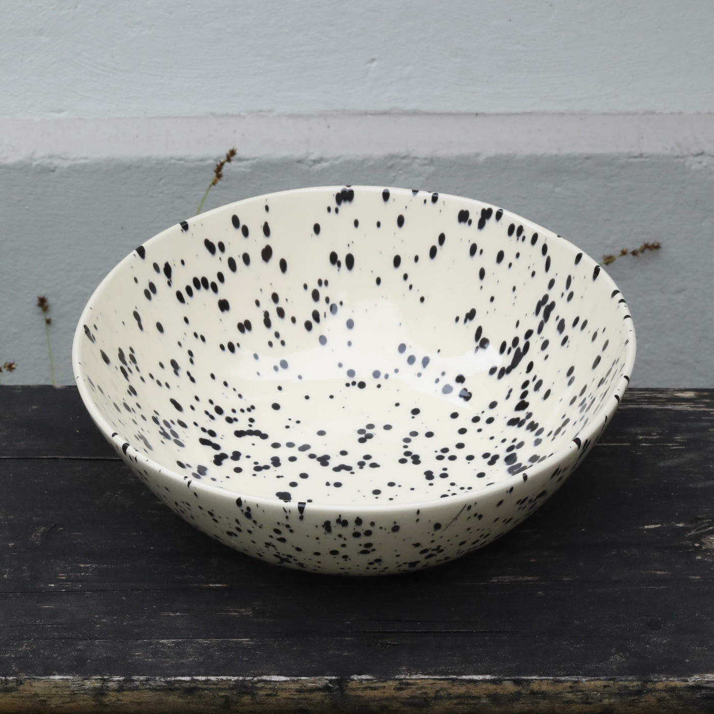 Saladier beige moucheté de noir sur fond boisé
