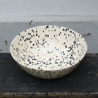 Saladier beige moucheté de noir sur fond boisé