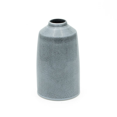 Vase bleu simple qui rétrécit vers le haut et offre une ouverture stable pour les bouquets de fleurs.