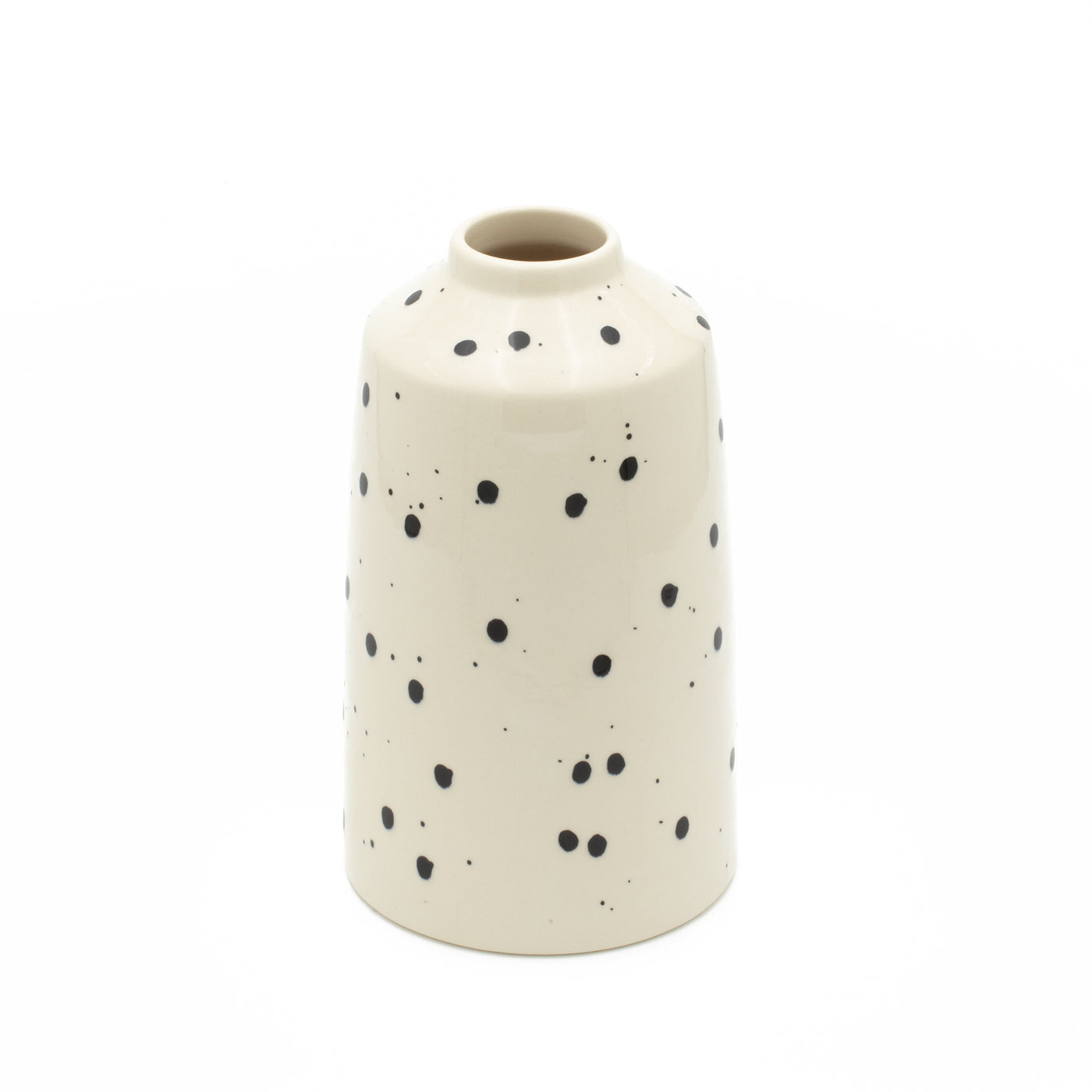 Vase de fleurs à pois noirs avec couleur beige dégagé sur fond blanc