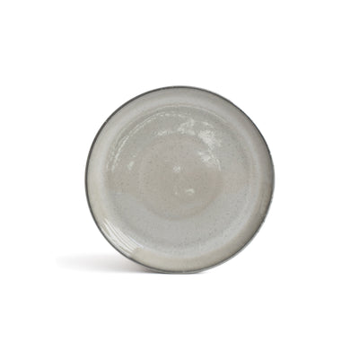 La petite assiette gris clair avec un bord gris foncé se détache sur un fond blanc.