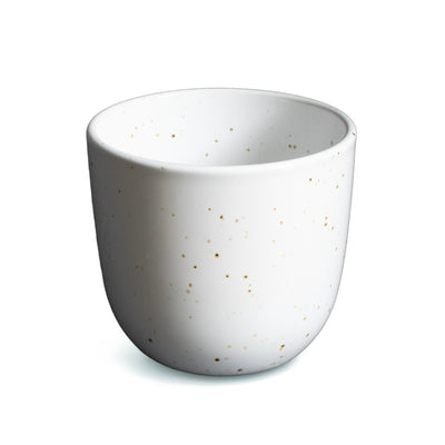 Tasse à café blanche sans anse avec de fins points dorés détachés sur fond blanc