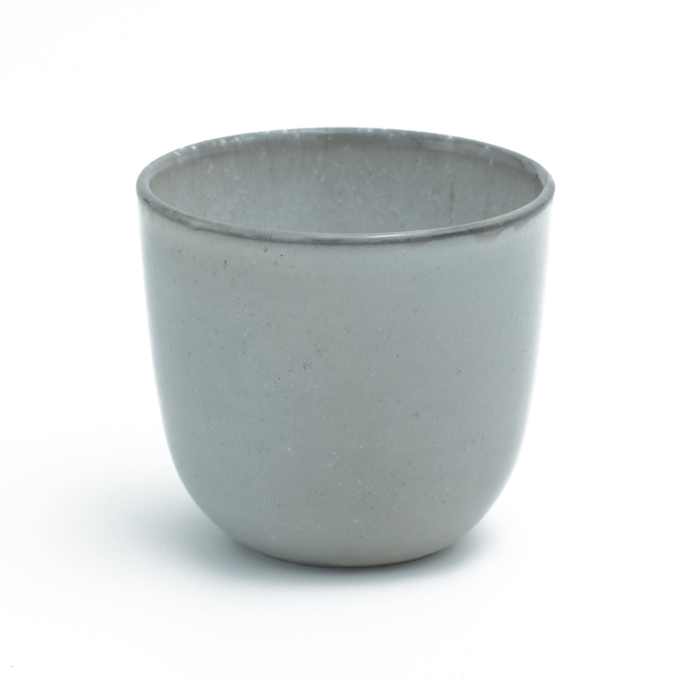Tasse à café gris clair sans anse sur fond blanc dégagé