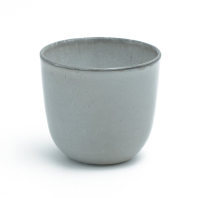 Tasse à café gris clair sans anse sur fond blanc dégagé