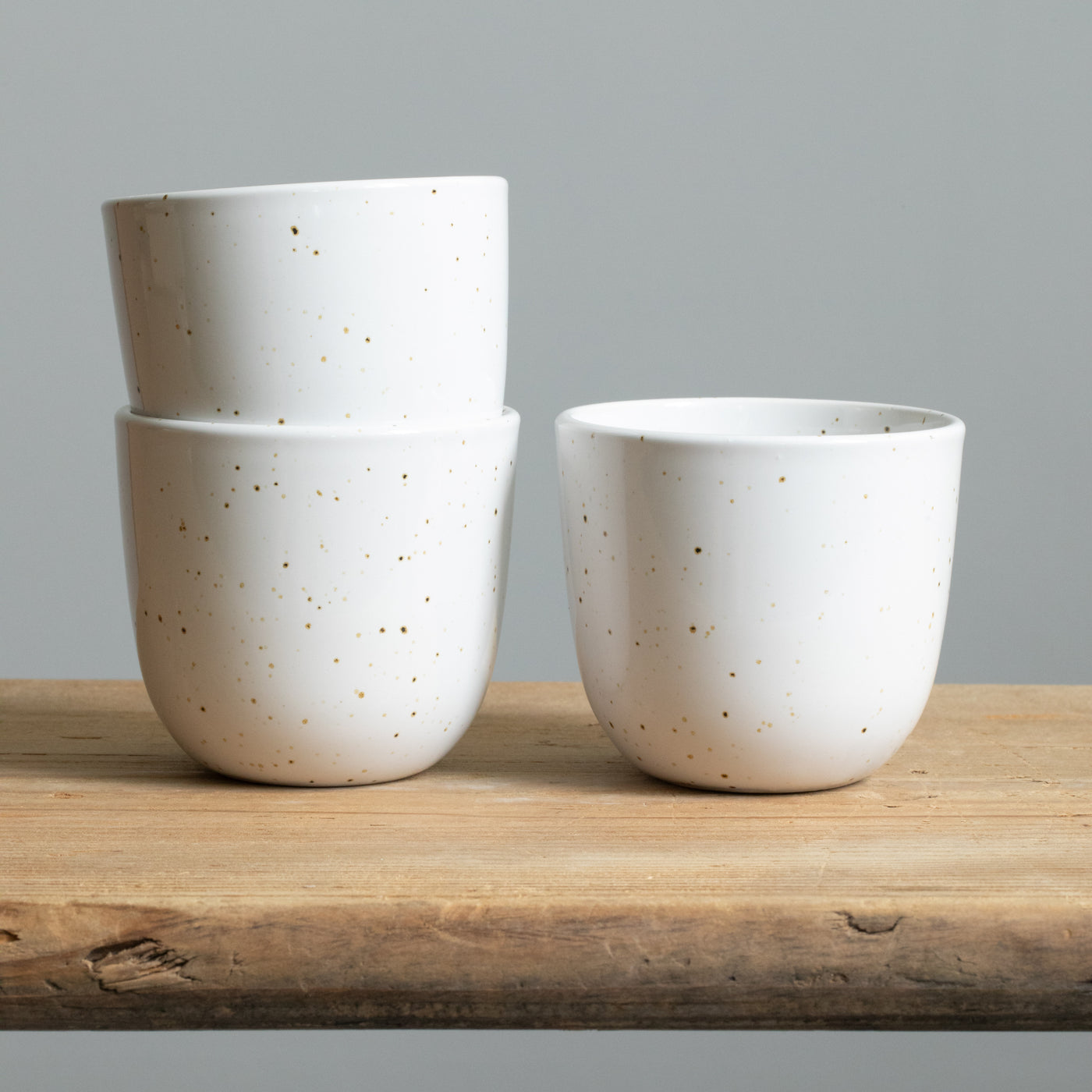 Deux tasses à cappuccino empilées de couleur blanche brillante avec des éclaboussures fines dorées