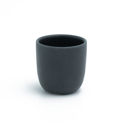 Tasse à expresso noire mate sans anse détachée sur fond blanc