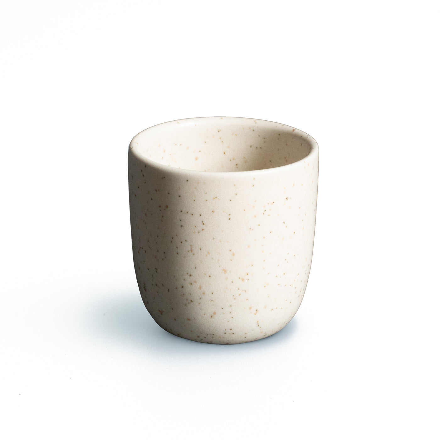Tasse à espresso beige mat sans anse sur fond blanc dégagé