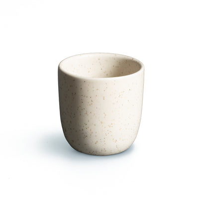 Tasse à espresso beige mat sans anse sur fond blanc dégagé