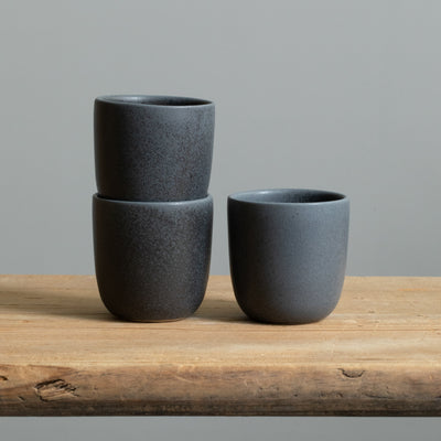 Trois tasses à espresso empilées, noires mates, au design épuré