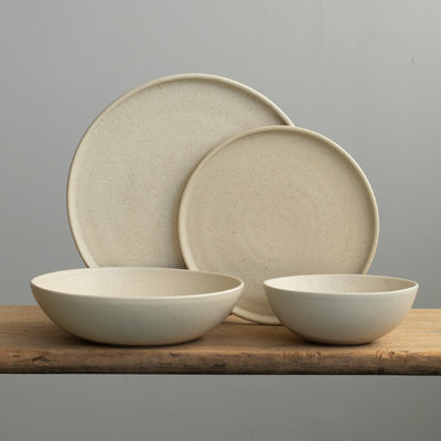 Set de vaisselle complet en émail beige avec une grande et une petite assiette, une assiette creuse à pâtes et un bol à muesli
