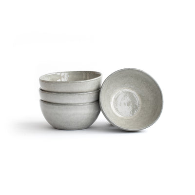 Trois Snack Bowl gris clair empilés et un Snack Bowl gris clair adossé dégagés sur fond blanc