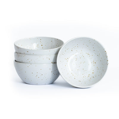 Trois grandes coupes à snacks empilées et une posée, de couleur blanche avec des éclaboussures brun doré, sur fond blanc.