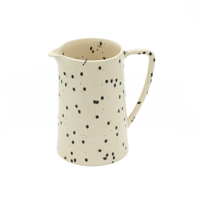 Pichet à grande anse d'une contenance de 2 l, de couleur beige à pois nets sur fond blanc.