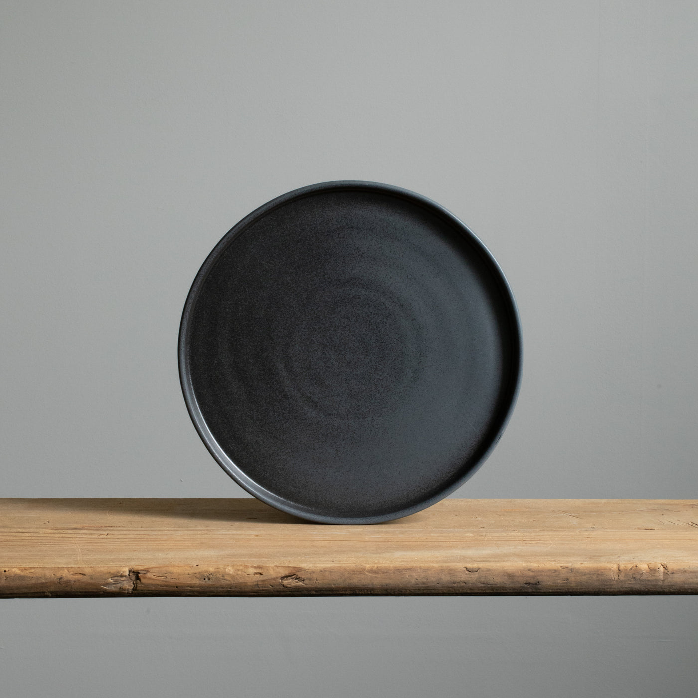 Grande assiette à bord coudé en grès émaillé noir mat