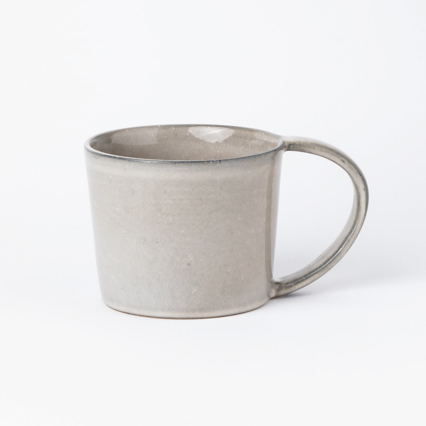 Grande tasse à thé avec anse en gris clair et une grande anse vue de face sur fond blanc