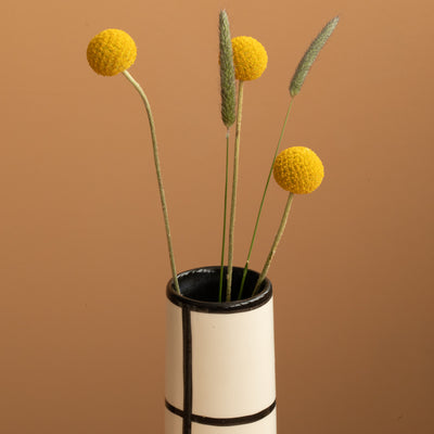 Détail de l'ouverture d'un vase fin à carreaux noirs qui ressemble à une cheminée