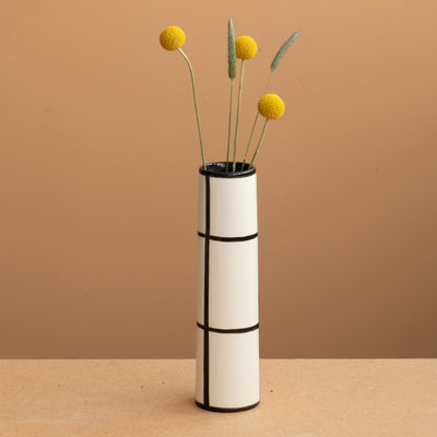 Vase fin de couleur blanche à carreaux noirs et fleurs jaunes et vertes