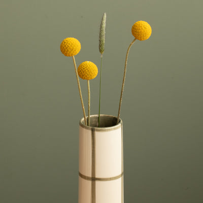 Détail de l'ouverture d'un vase fin et étroit devant des carreaux verts avec de grands champs blancs