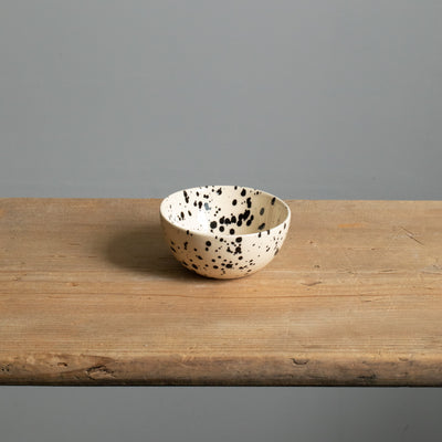 Petit snack bowl avec glaçage couleur crème et points noirs parfait pour les noix et les dips