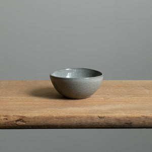 Petit bol en émail brillant gris foncé parfait pour les antipasti seul sur une table en bois