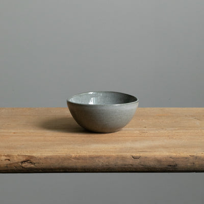 Petit bol en émail brillant gris foncé parfait pour les antipasti seul sur une table en bois