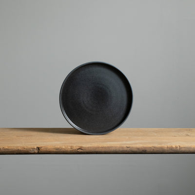 Petite assiette à hors-d'œuvre présentée en couleur noire mate avec bord coudé