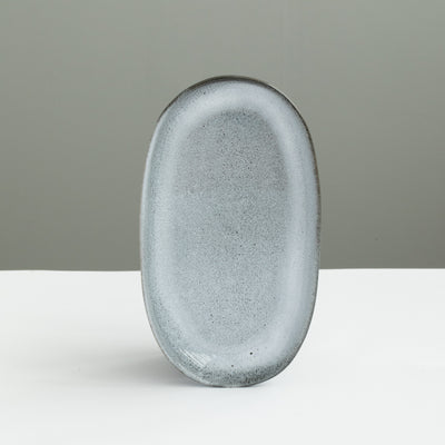 Assiette ovale de 22 cm de long, parfaite comme soucoupe ou assiette à hors-d'œuvre, en émail bleu chiné réactif.