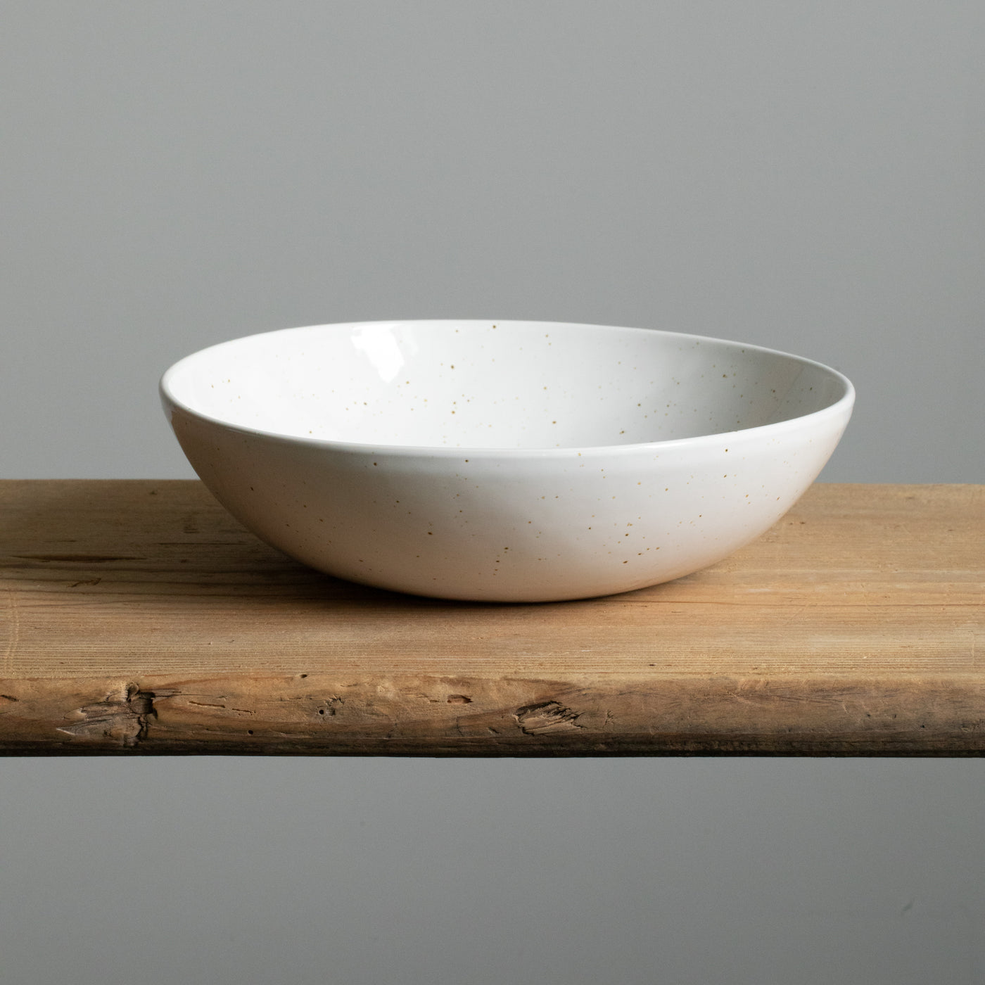 Grande assiette ronde de pâtes blanche vue de face sur une table en bois