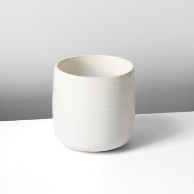 Tasse blanche avec de fines rainures horizontales parfaite pour un grand café ou un thé