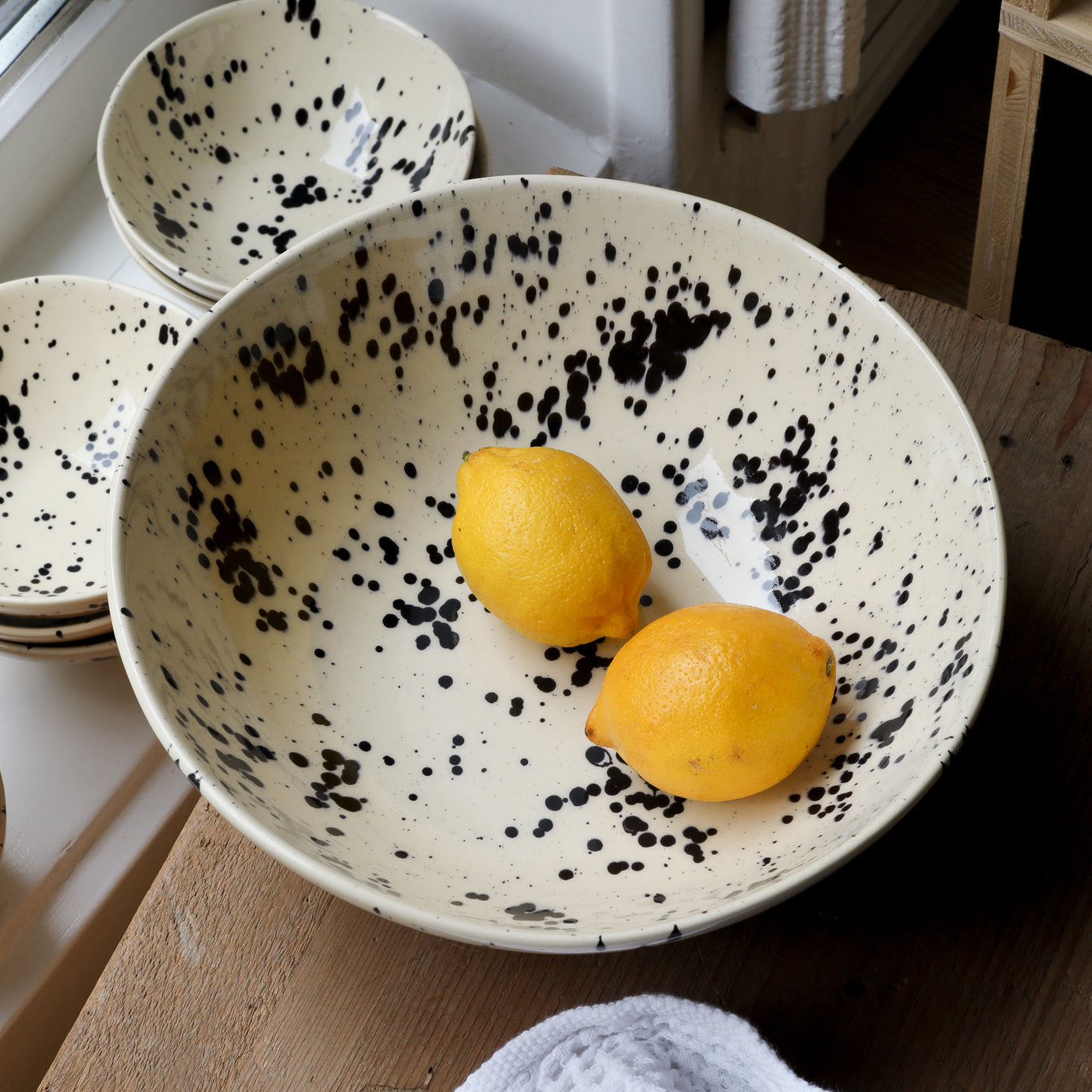 Deux citrons sont posés dans le saladier beige à pois noirs