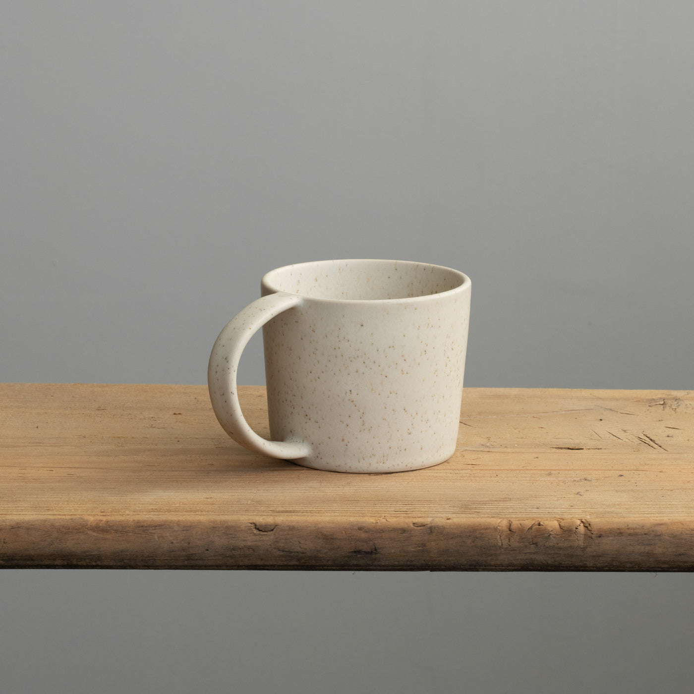 Tasse à thé beige avec anse sur une table en bois