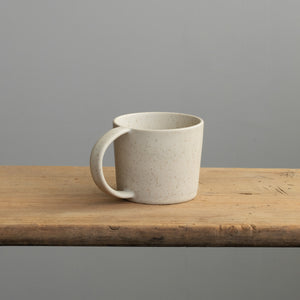 Tasse à thé beige avec anse sur une table en bois