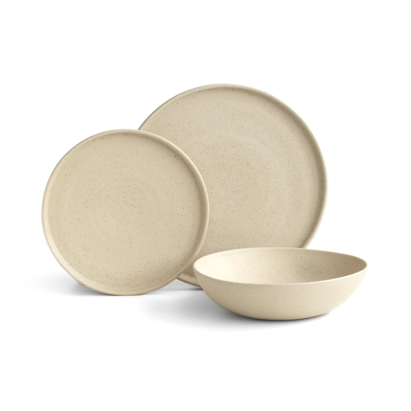 Une grande et une petite assiette à bord droit placées devant une assiette de pâtes de couleur Speckled Beige sur fond blanc dégagé