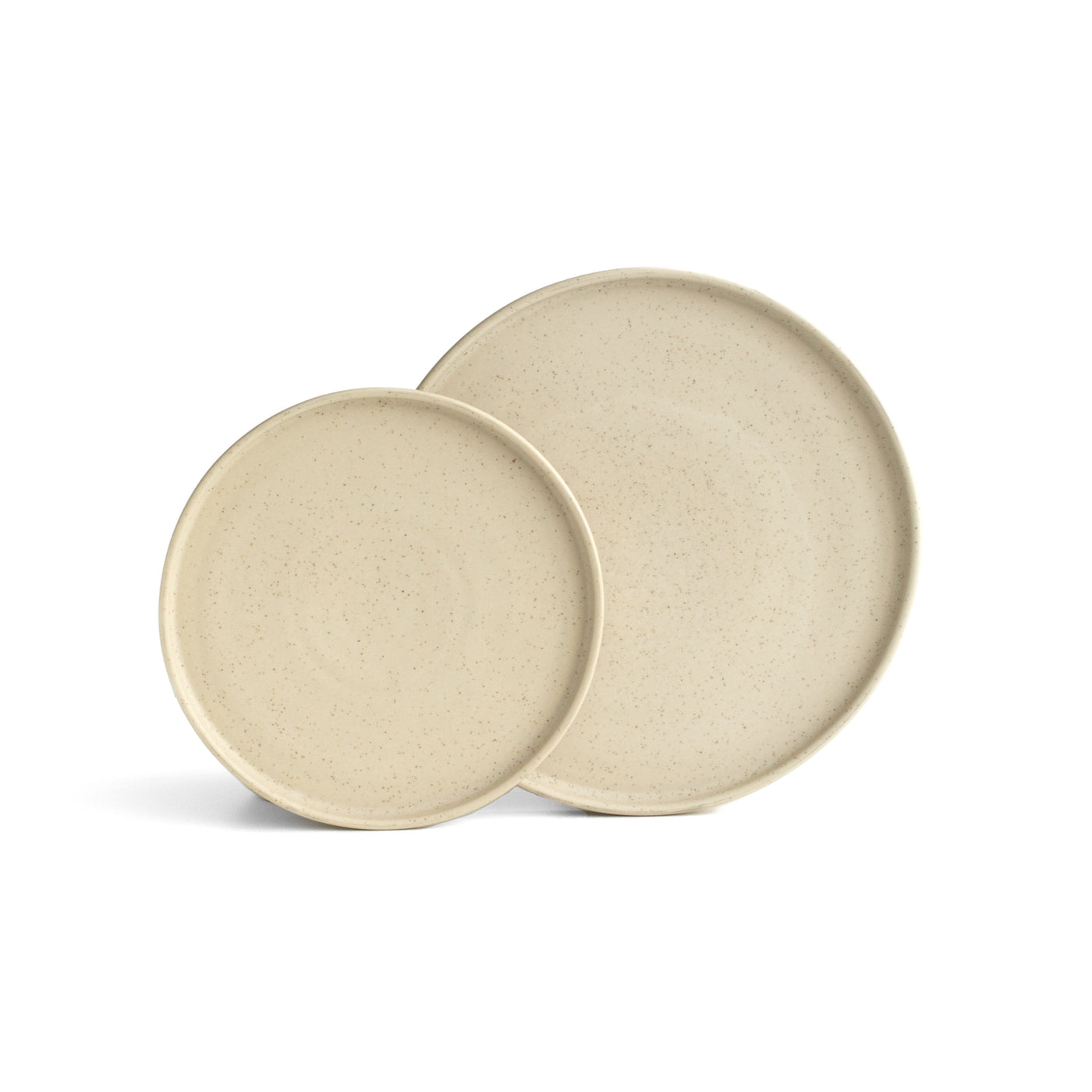 Une grande et une petite assiette de couleur beige légèrement chiné avec un bord droit posée et dégagée