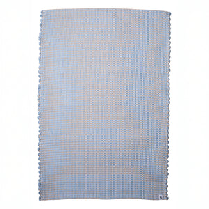 Petit tapis bleu clair à rayures de jute, fait de restes de laine tissés à la main au Portugal, avec des motifs blancs.